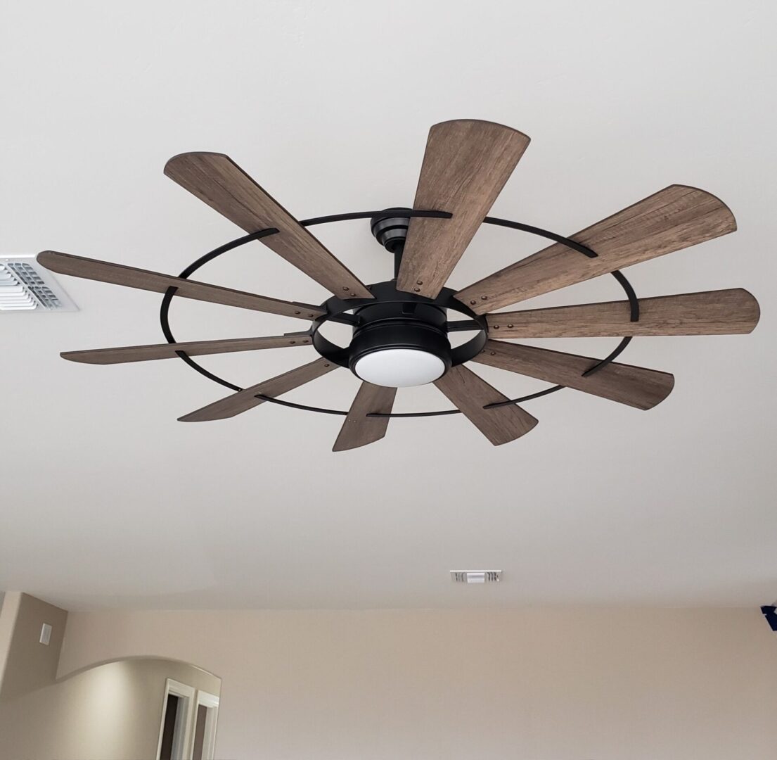 A ceiling fan with wooden blades and black frame.