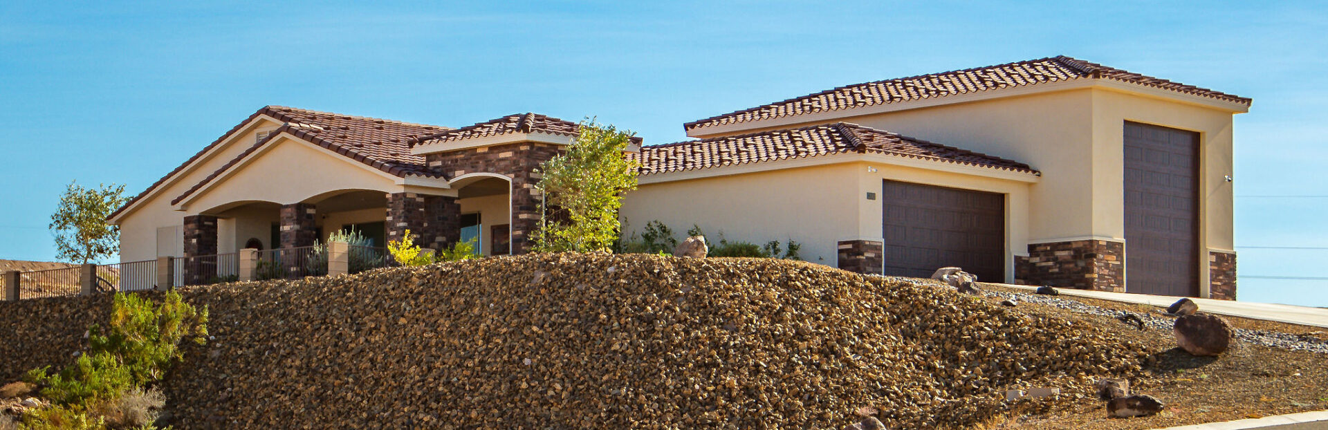 A large pile of mulch in front of a house.